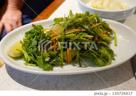 Fresh vegetable salad with a vibrant mix of greens, cherry tomatoes, cucumbers, and bell peppers. Crisp, colorful, and packed with vitamins, this salad makes a healthy, delicious meal or side. 130726817