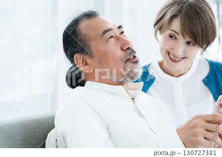 ソファで話すシニア夫婦 130727381