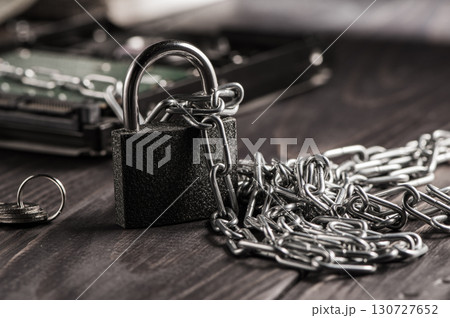 The padlock with metal chains symbolizes strong protection and access restriction 130727652