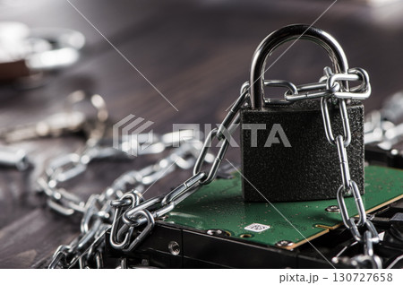 The hard disk is encased in metal chains that emphasize the high level of cyber security 130727658