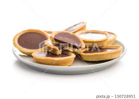 Sweet chocolate tartelettes isolated on white background. Sweet chocolate tartelettes isolated on white background. 130728951