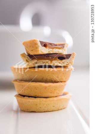 Sweet chocolate tartelettes on white table. 130728953