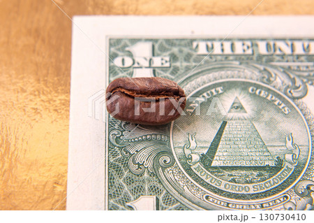 split coffee bean lies on a U.S. one-dollar bill, blending earthy brown with the bill split coffee bean lies on a U.S. one-dollar bill, blending earthy brown with the bill 130730410