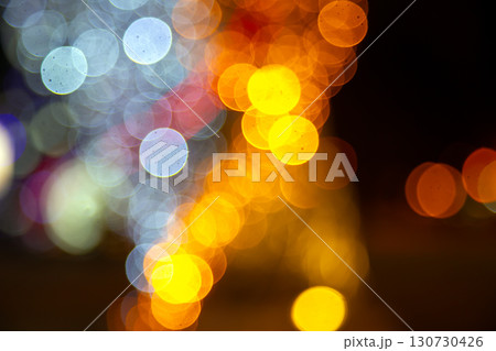 A magical bokeh pattern of golden and colorful lights on a dark background 130730426