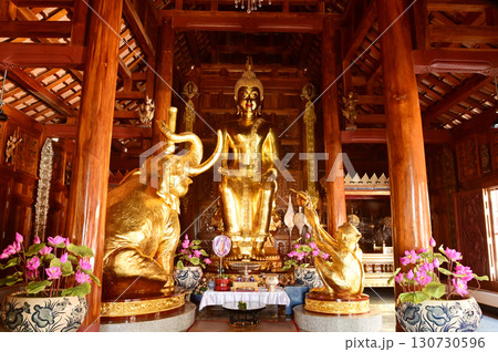 The golden Buddha statue Receiving Offerings from an Elephant and a Monkey (Parileyyaka) in the chapel at Wat Den Sali Si Mueang Kaen temple or Wat Ban Den. Located at Chiang Mai Province in Thailand. 130730596