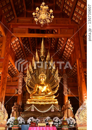 Golden sitting Buddha statue and there is a serpent covering the back in Buddhist Thai Church at Wat Den Sali Si Mueang Kaen temple. Located at Chiang Mai city in Thailand. Golden sitting Buddha statue and there is a serpent covering the back in Buddhist Thai Church at Wat Den Sali Si Mueang Kaen temple. Located at Chiang Mai city in Thailand. 130730607