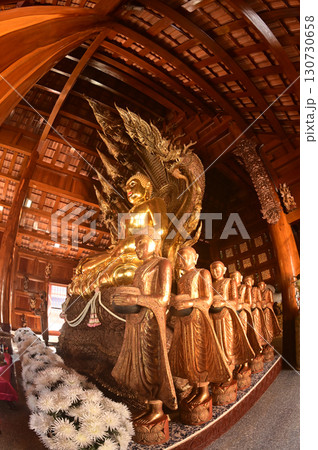 Golden sitting Buddha statue and there is a serpent covering the back in Buddhist Thai Church at Wat Den Sali Si Mueang Kaen temple. Located at Chiang Mai city in Thailand. 130730658
