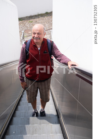 elderly man going up escalator in Portugal to fortress 130732305