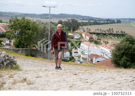 elderly man walking in Portuguese village and enjoying the views 130732313