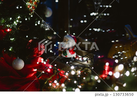A christmas tree with a santa sitting on a bench A christmas tree with a santa sitting on a bench 130733650