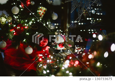 A christmas tree with a santa sitting on a bench A christmas tree with a santa sitting on a bench 130733675