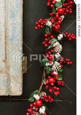 A red and white Christmas wreath with red berries and white cotton balls A red and white Christmas wreath with red berries and white cotton balls 130733679