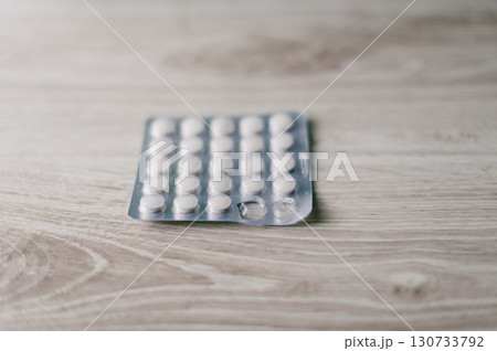 A box of pills is on a wooden table A box of pills is on a wooden table 130733792