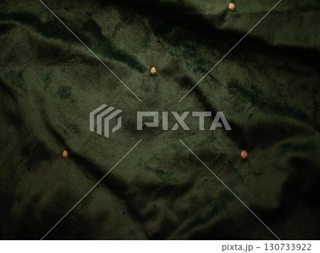 A green fabric with a pattern of small dots 130733922