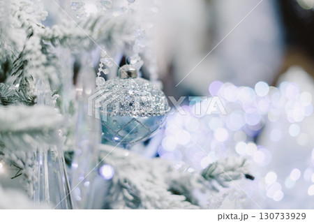 A Christmas tree with a blue ornament hanging from it 130733929