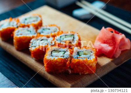 A plate of sushi with a garnish of wasabi and cucumber A plate of sushi with a garnish of wasabi and cucumber 130734121