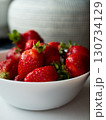 Strawberries in a bucket on a white wooden table 130734129