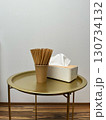A tray with a white tissue box and a cup of straws on it 130734132