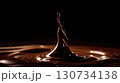 Chocolate drop is falling into a pool of chocolate. Moody and dark atmosphere 130734138