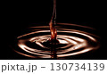 Drop of chocolate is falling into a pool of chocolate. Moody and dark atmosphere 130734139