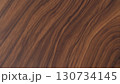 Wooden surface with a grainy texture. The wood appears to be of a darker color, possibly mahogany or oak. The grain of the wood is visible, giving the surface a natural and rustic appearance 130734145