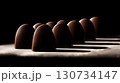 Row of chocolate truffles are lined up on a table. Chocolate bar is a symbol of a sweet treat 130734147