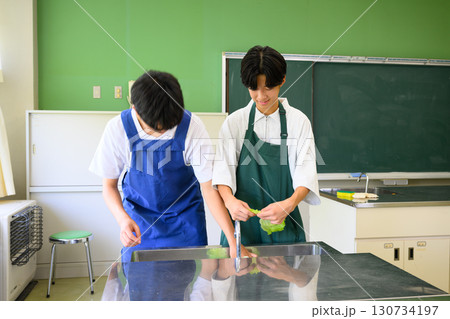 料理教室で学ぶ男子学生　二人で楽しくクッキングするシーン 130734197