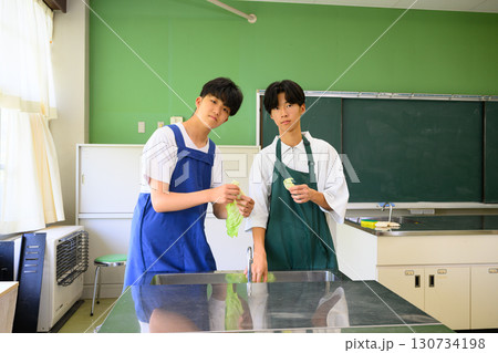 料理教室で学ぶ男子学生　二人で楽しくクッキングするシーン 130734198
