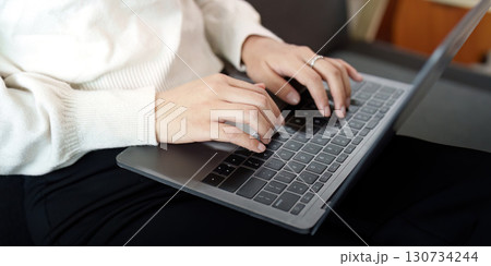 Productivity. Young woman typing on a laptop at home. Productivity. Young woman typing on a laptop at home. 130734244