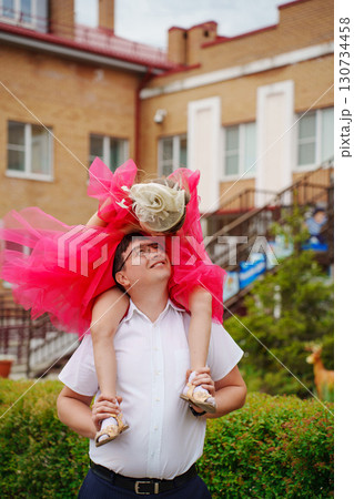 Happy well-dressed family on a walk. Dad and little daughter  130734458