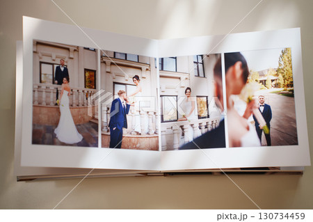 an open photo book with wedding photos on a white table 130734459