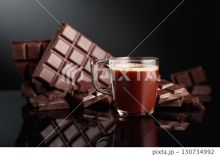 Glass mug of hot chocolate and broken bitter chocolate bar. Glass mug of hot chocolate and broken bitter chocolate bar. 130734992