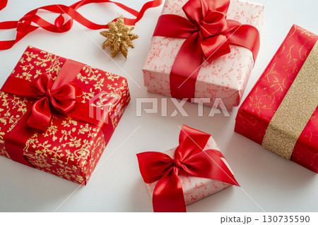 Multiple red and gold festive wrapped gift boxes with decorative ribbons and bows. Holiday presents beautifully arranged on a bright white background with a star. Multiple red and gold festive wrapped gift boxes with decorative ribbons and bows. Holiday presents beautifully arranged on a bright white background with a star. 130735590