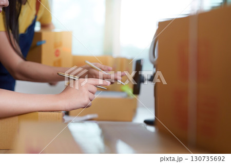 E-commerce Focus. Women working on tasks with attention in a modern workspace. 130735692