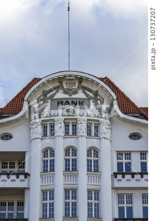 Historic bank building with ornate white facade, classical columns, displaying BANK sign and 1908, embodying financial history and urban architecture 130737207