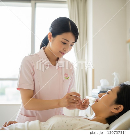 入院中の患者の横で検査のじゅんびをする若い女性看護師 130737514