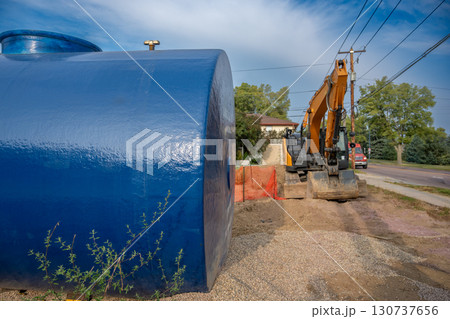 Selective focus on a construction site installing a new underground storage tank at a gas station. Selective focus on a construction site installing a new underground storage tank at a gas station. 130737656