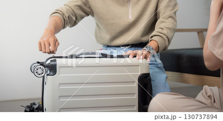 Travel Preparation. Man fixing suitcase for upcoming trip. 130737894