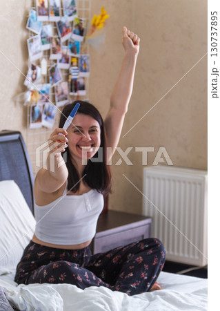 Surprised Woman with Positive Pregnancy Test 130737895