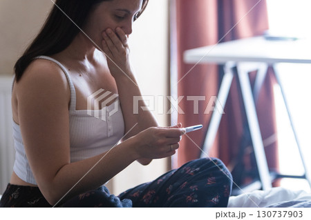 Surprised Woman with Positive Pregnancy Test 130737903