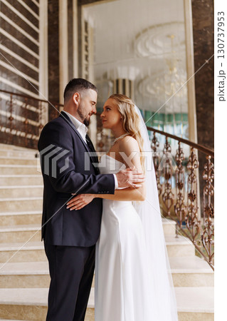 The bride and groom are on a beautiful staircase. The bride and groom are on a beautiful staircase. 130737953