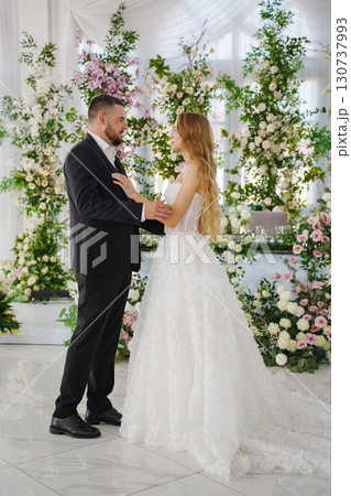 Beautiful and in love newlyweds dance in a banquet hall 130737993