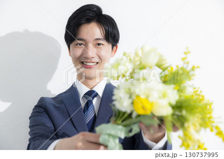花束を差し出すビジネスマン　 130737995