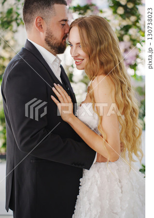 Beautiful and gentle bride and groom on the background of flowers in the decor. 130738023