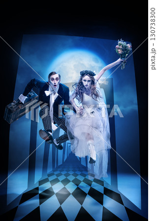 Zombie bride and groom jumping through surreal corridor with full moon backdrop 130738300