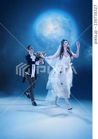 Dark romantic chase of gothic bride and groom in moonlit fantasy scene 130738327