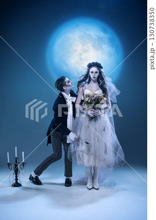 Gothic bride holding bouquet with groom in surreal moonlit horror wedding Gothic bride holding bouquet with groom in surreal moonlit horror wedding 130738350