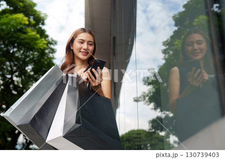 Shopping and Digital Engagement. Young woman enjoying shopping experience with smartphone. 130739403