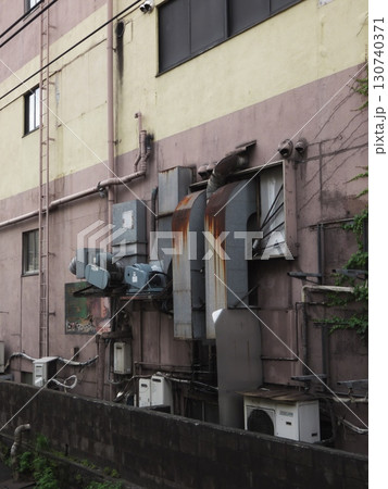 雑多な配管と錆びたダクトがむき出しのビル側面 130740371