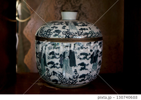 A decorative ceramic jar with a lid, adorned with blue and white artwork 130740688